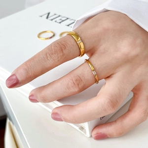 Slim gold rainbow ring set with cubic zirconia and star motif on woman's hand