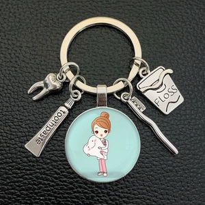 Detail of creative keychain with dental charms like tooth, toothpaste, and floss pendant