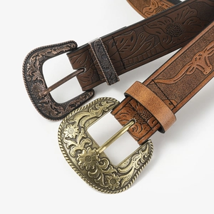 Detailed view of vintage embossed leather belts with antique gold and bronze buckles
