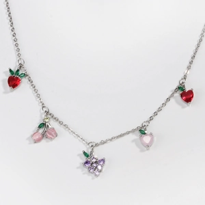 Macro detail of silver necklace with colorful zircon fruit pendants including strawberry and cherry