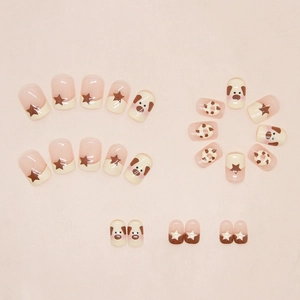 Détails de faux ongles courts ronds avec motifs de chiens et étoiles brunes sur crème
