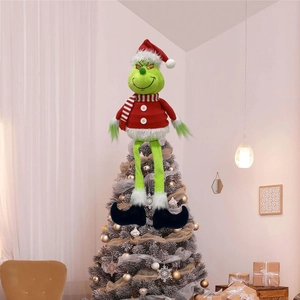 Grinch plush Christmas tree topper wearing a red hat and striped scarf on tree