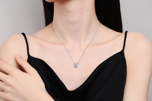 Close-up of a pear-cut moissanite pendant necklace worn by a model on the collarbone