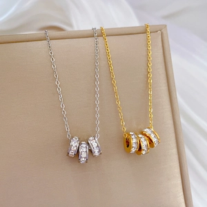 Titanium steel triple-ring pendant necklaces in gold and silver finishes on silk