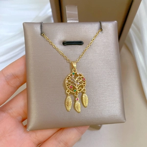 Macro view of golden dreamcatcher necklace with colorful stones and tree of life detail