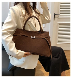 Detail view of dark brown suede tote bag featuring strap buckle and dual top handles