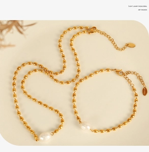 Close-up of gold stainless steel jewelry set with elegant white oval pearls and chain