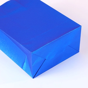 Glossy blue gift bag showing a close-up view of the sturdy folded bottom structure