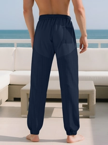 Outdoor back view of men's casual trousers featuring navy blue patchwork textured fabric