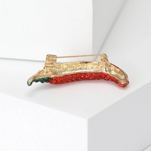 Creative red rhinestone chili pepper brooch with gold metal base on white pedestal