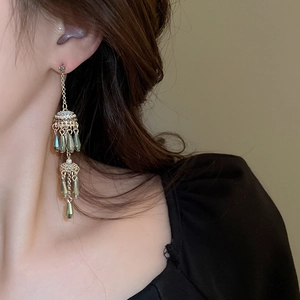 Detailed view of vintage fringe earrings with blue-grey teardrop beads on a side profile