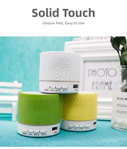 Detail view of mini crackle pattern Bluetooth speakers in white green and yellow finishes
