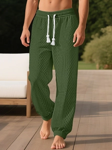 Détail du jogging vert foncé à texture jacquard avec cordon blanc et chevilles élastiques