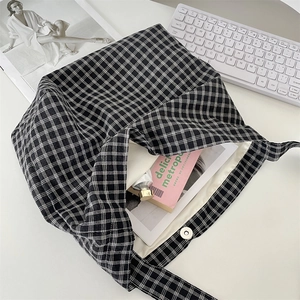 Close-up of canvas tote bag showing magnetic buckle closure and checkerboard pattern