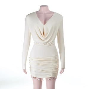 Détail de robe dos nu crème avec décolleté en V profond, plis et ourlet à franges pailletées