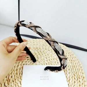 Detalle de la diadema trenzada con brillantes de imitación en plata y oro champán