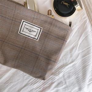 Close-up of retro plaid cosmetic bag with TIME TO PARTY patch and golden zipper
