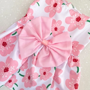 Detailed top view of pink floral pet dress with a large silk bow and cherry blossom print