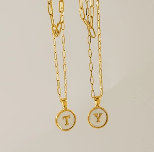 Détail de colliers en trombones dorés avec pendentifs lettres T et Y ronds