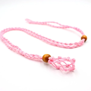 Detalle de collar de macramé rosa tejido a mano con cuentas de madera y bolsa de red pequeña