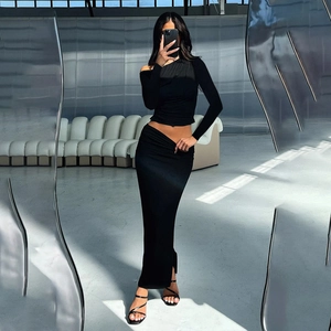 Detail of black two-piece set with long-sleeve crop top and slim skirt in metallic setting