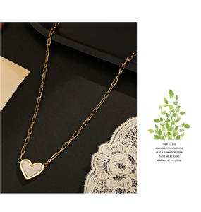 Macro shot of 14K gold-plated heart pendant with mixed metal textures and vintage lace