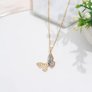 Detailed close-up of golden bow pendant with sparkling zircon and blue gradient inlay
