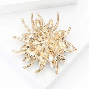 Detail view of the secure pin clasp on the back of the golden floral alloy brooch