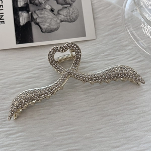 Dettaglio ravvicinato di un fermaglio per capelli in argento con strass e cuore