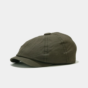 Detailed side view of a dark olive green newsboy cap with premium twill fabric textures