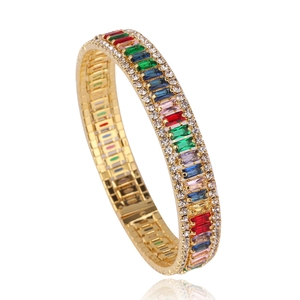 Luxury gold bangle with rainbow square-cut zircons and pavé side crystals on white background