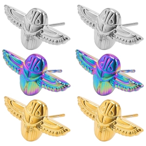 Macro detail of scarab beetle earrings in silver, gold, and iridescent metal finishes