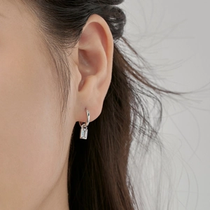Detail of S925 sterling silver hoop earrings with geometric zircon heart charms on a model