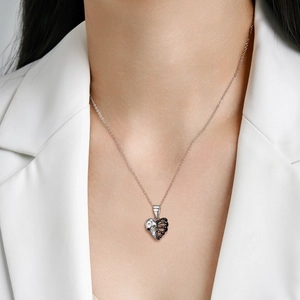 Punk S925 silver skeleton heart pendant necklace worn by a model in white suit