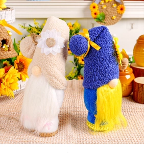 Detail of plush gnome dolls featuring sunflower and daisy motifs with long soft beards