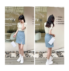 Close-up of knit short-sleeved V-neck top with slit skirt and white textured handbag