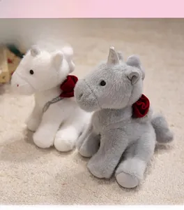 Detail of plush unicorn toys featuring silver horns and red rose neck decorations