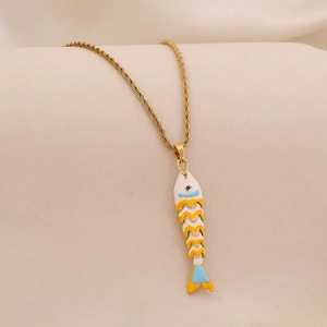 Macro detail of golden fish pendant with colorful enamel and sparkling rhinestones