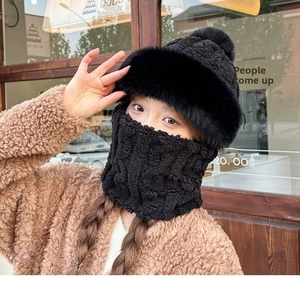Detailed view of the thick black knitted hat with faux fur trim and matching neck warmer
