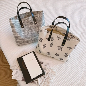 Détail de sacs fourre-tout en toile vintage avec poignées en cuir et broderies