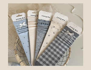 Detailed view of various cute bow socks in a vintage basket with lace background