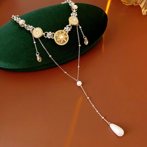 Detail view of multi-layer gold and silver necklace with crystals and pearl drops