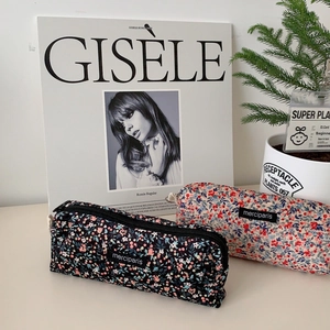 Floral corduroy pencil case and cosmetic pouch with merciparis woven label on desk