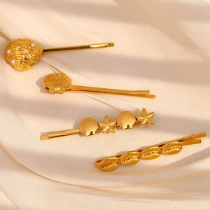 18K gold-plated shell and starfish hair clips set on elegant cream silk fabric