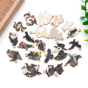 Detailed flat lay of gothic crow and plague doctor enamel metal charms for jewelry making