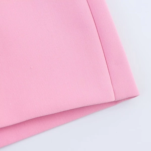Detail shot of pink woven fabric texture and high-quality stitching on split skirt pants