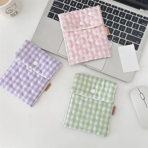 Detailed macro view of quilted cotton mini pouches with snap closure and brand label