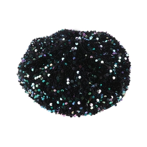 Detailed close-up of shiny black sequins and soft velvet texture on a stylish beret hat