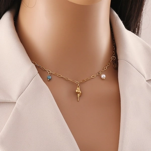 Gold necklace with seashell pendant, blue turquoise bead, and pearl on model