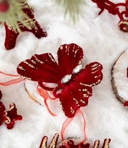 Détail du papillon de Noël en velours rouge avec paillettes dorées et strass brillants